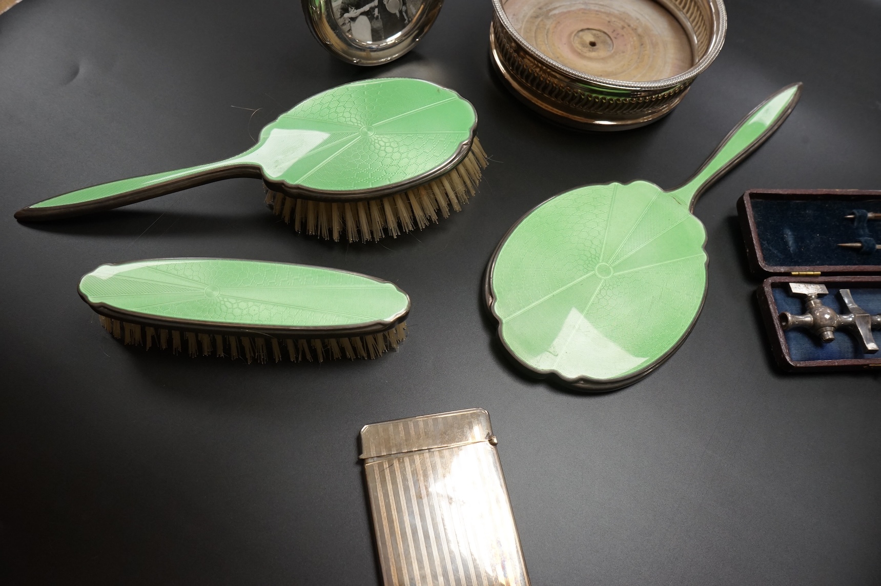 A George V silver rectangular card case by William Henry Sparrow, Birmingham, 1913, 89mm, a modern silver mounted circular photograph frame and five other items including a three piece silver plate and enamel mirror and